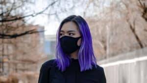 Jeune fille aux cheveux violets avec un masque en tissu