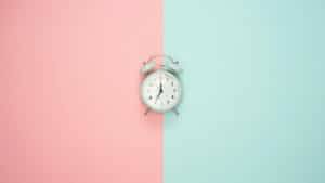 Horloge sur fond pastel indiquant le temps de la tenue d'une coloration