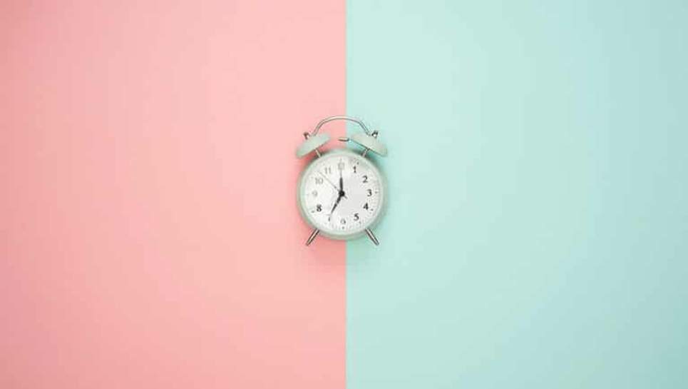 Horloge sur fond pastel indiquant le temps de la tenue d'une coloration