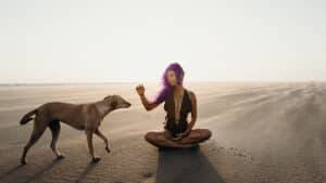 Une fille aux cheveux violet avec son chien à la plage
