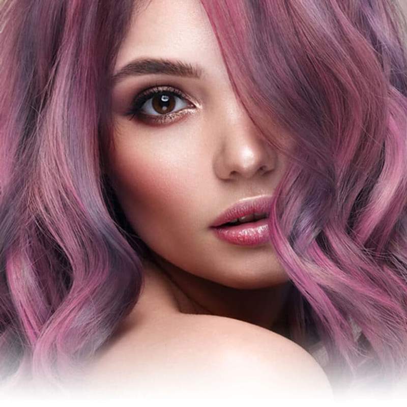Portrait rapproché de femme aux cheveux colorés avec les colorations permanentes Yummy Colours, dans les tons de violet, lavande et gris foncé